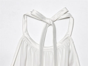 Detalle de blusa de satén blanco con cuello halter y lazo decorativo en la parte posterior