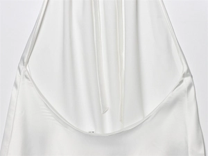 Detalle posterior de un top halter de satén blanco con espalda abierta y cuello anudado