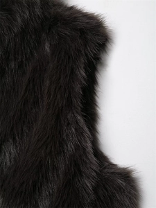 Close-up detail of smooth long black faux fur vest texture with glossy synthetic fibers