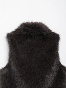 Detailed macro view of dark brown faux fur texture with long smooth fibers on a vest