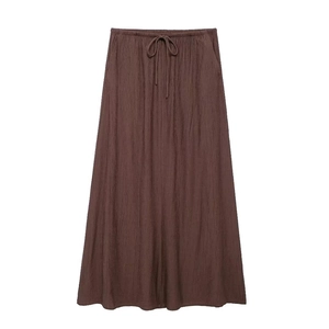 Détail d'une jupe longue marron foncé à texture verticale, taille élastique et cordon