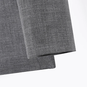 Primer plano de la textura tejida en espiga gris y detalle de hombrera de la chaqueta