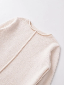 Dettaglio del maglione beige in maglia a coste con scollo rotondo e cucitura verticale