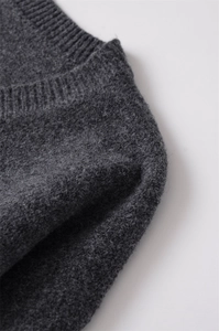 Détails macro d'un tricot gris anthracite montrant la texture côtelée et la laine douce