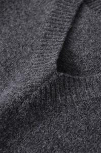 Vue macro détaillée de la maille en laine gris anthracite et couture du col en V