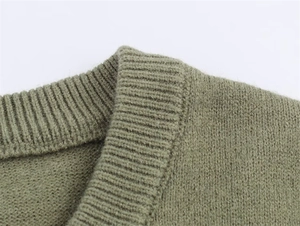 Detailed macro view of the olive green ribbed knit neckline and fuzzy soft sweater fabric
