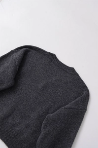 Détail du tricot gris anthracite montrant le col rond et la texture des côtes douces