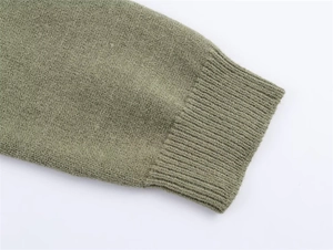 Detailed macro view of soft sage green knit sweater showing fine texture and ribbed cuffs