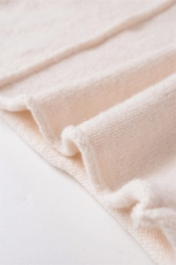 Dettaglio della trama in maglia a coste bianco avorio con bordi ondulati elastici e morbidi