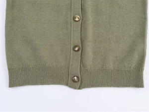 Detail of sage green knit cardigan showing faux horn buttons and ribbed hem texture
