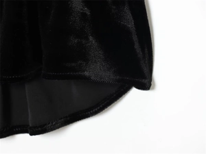Detailed close-up of the smooth hem stitching and luxurious black velvet fabric texture