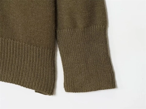 Detailed view of the ribbed cuffs and hem on this olive green V-neck knitted sweater