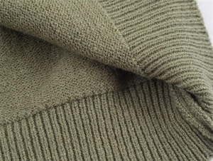 Close-up of olive green knit fabric showing smooth stitch and ribbed hem texture