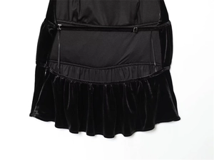 Detailed macro view of black velvet fabric with delicate thin straps and ruffle hem design