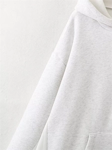 Detail of grey hooded sweatshirt showing high-quality stitching and cotton knit texture
