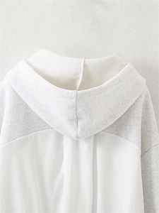 Detailed back view of white and light gray spliced hooded sweatshirt with neat stitching