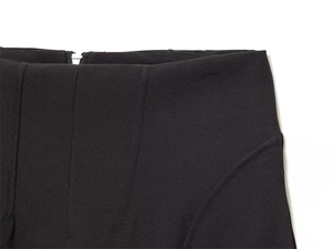 Dettaglio ravvicinato di pantaloni neri a vita alta con cuciture verticali e zip posteriore