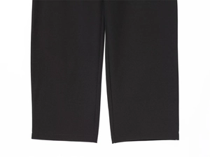 Dettaglio della cucitura liscia e della trama del tessuto nero di questi pantaloni a vita alta