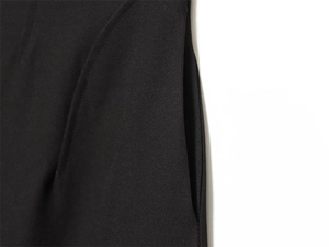 Dettaglio dei pantaloni neri a vita alta con cuciture rifinite e pratica tasca a scomparsa