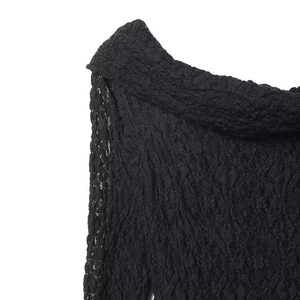 Detailed macro shot of elegant black floral lace fabric on a scalloped off-shoulder neckline