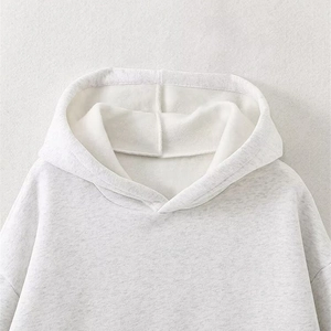 Close-up of minimalist light grey hooded sweatshirt with soft fleece lining and drop shoulder