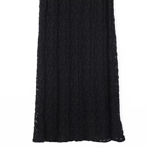 Detailed close-up of intricate black lace embroidery on the bottom hem of the dress