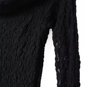 Close-up of black lace fabric texture on long sleeve dress with unique bubble pattern