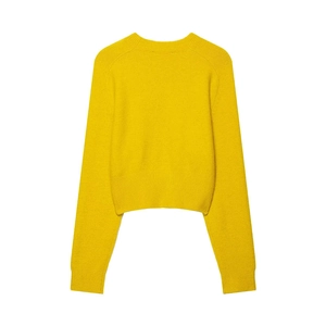 Detail of soft yellow knit sweater showing ribbed cuffs and neckline texture