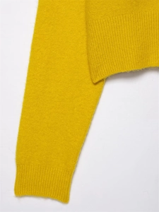 Detailed close-up of soft ginger yellow knit sweater texture and ribbed cuff design