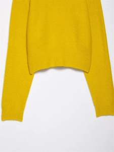 Detail shot of the ribbed knit hem and soft texture of the yellow wool sweater