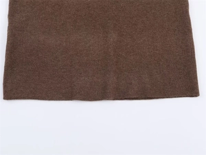 Close-up detail of dark brown knit pullover sweater with vertical rib texture