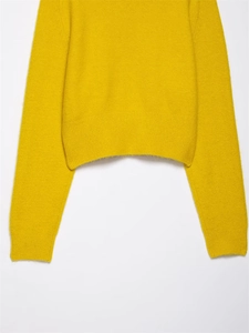 Detailed view of bright yellow knit sweater featuring ribbed hem and fuzzy mohair texture