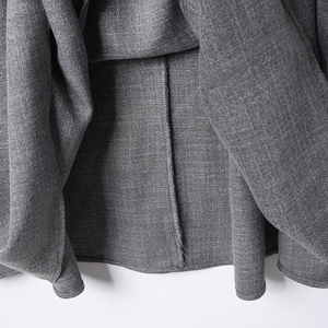 Detalle de la tela de falda midi gris oscuro con dobladillo y costuras internas de calidad