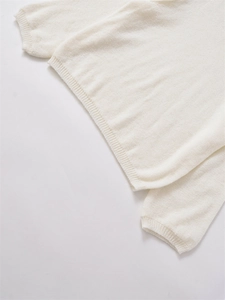 Detailansicht der cremefarbenen Stricktextur mit Rippsaum und weichem Stofffinish