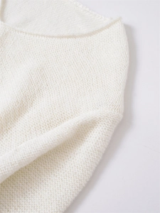 Detailansicht eines weißen Feinstrickpullovers mit Rollsaum am Ausschnitt und flauschiger Textur