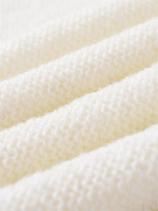 Nahaufnahme der cremeweißen Strickstruktur mit hochwertigen Details aus Wollmischgewebe
