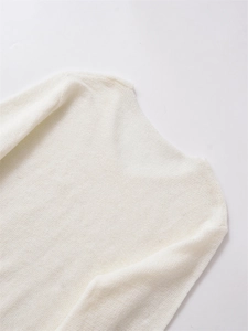 Detailansicht des Ausschnitts und der Schulter eines weichen weißen Strickpullovers