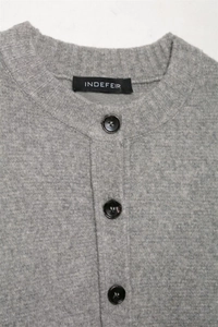 Detalle de cárdigan de punto gris con cuello redondo y tres botones negros elegantes
