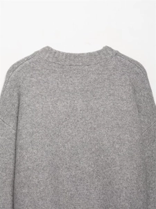 Primer plano del suéter de punto gris con cuello redondo acanalado y textura suave