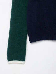 Détail d'un pull en tricot bleu et vert montrant la texture mohair et les poignets blancs