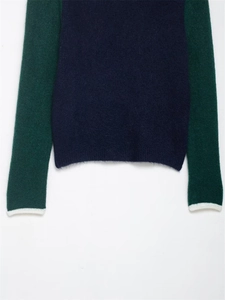 Détail de la texture d'un pull en maille mohair contrastée marine et manches vertes