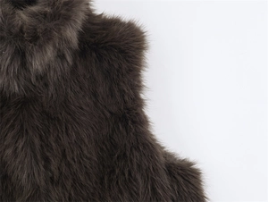Close-up of deep brown faux fur vest texture showing thick glossy plush material fibers