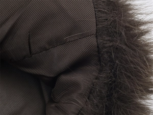 Detailed close-up of brown twill fabric lining and soft faux fur collar texture