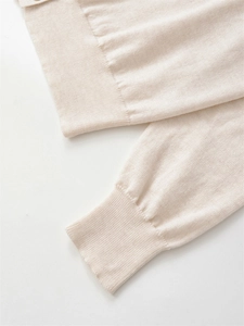 Makro-Detail der gerippten Manschette an der beigen Strickjacke mit Textur