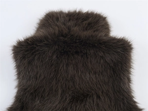 Close-up detail of plush deep brown faux fur vest texture on light grey background