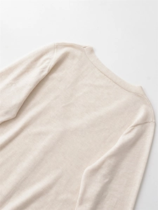 Detaillierte Nahaufnahme eines beigen V-Ausschnitt-Pullovers mit feiner Textur und Stoff