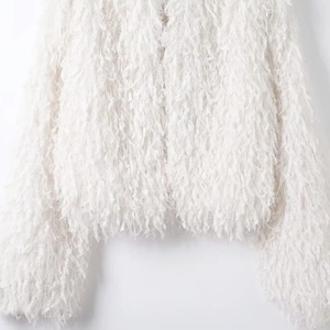 Detail of white feather-textured jacket showing soft fringe fabric and premium material