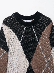 Nahaufnahme des Strickpullovers mit Rautenmuster in Schwarz, Weiß und Braun Details