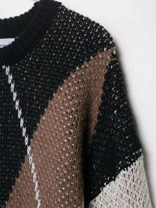 Nahaufnahme von Strickpullover mit geometrischem Rautenmuster und Rippstrick-Rundhalsausschnitt