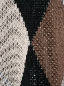 Detaillierte Makroansicht der geometrischen Strickstruktur und des dreifarbigen Musters